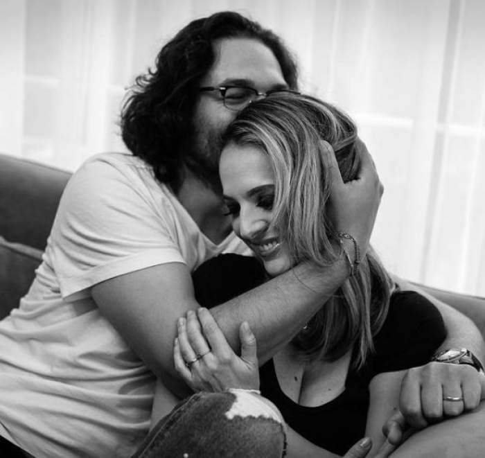 Florin Dumitrescu în timp ce o sărută pe cap pe soția sa, imagine alb negru.