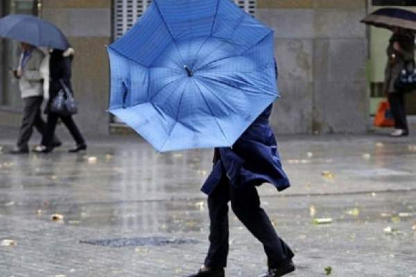 o femeie cu umbrela in ploaie