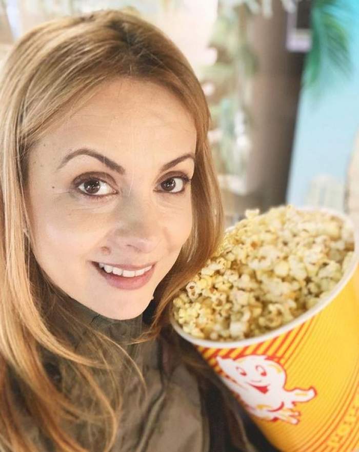 Simona Gherghe își face un selfie ținând o cutie de popcorn în brațe. Vedeta zâmbește.