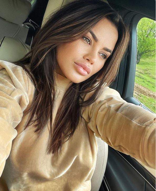 Carmen de la Sălciua își face un selfie din mașină, purtând o bluză bej.