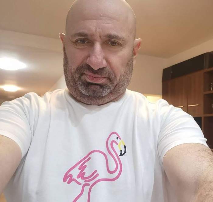 Cătălin Scărlătescu își face un selfie. Chef-ul poartă un tricou alb cu desen cu flamino roz în centru.