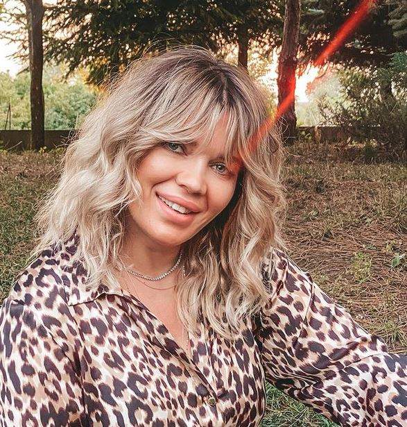 Gina Pistol e îmbrăcată într-o cămașă cu animal print, stil leopard. Vedeta zâmbește larg.