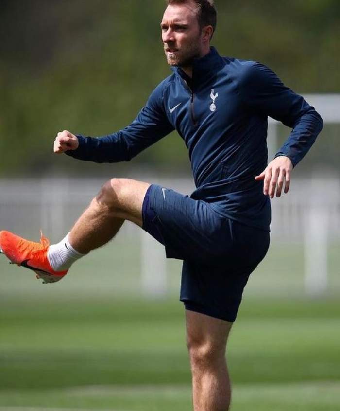 Christian Eriksen e pe teren, la antrenamentul de fotbal. Jucătorul poartă echipament bleumarin și încălțări oranj.