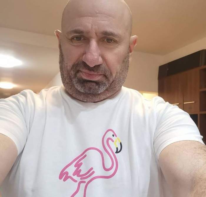 Cătălin Scărlătescu își face un selfie. Chef-ul poartă un tricou alb cu desen cu flamino roz în centru.