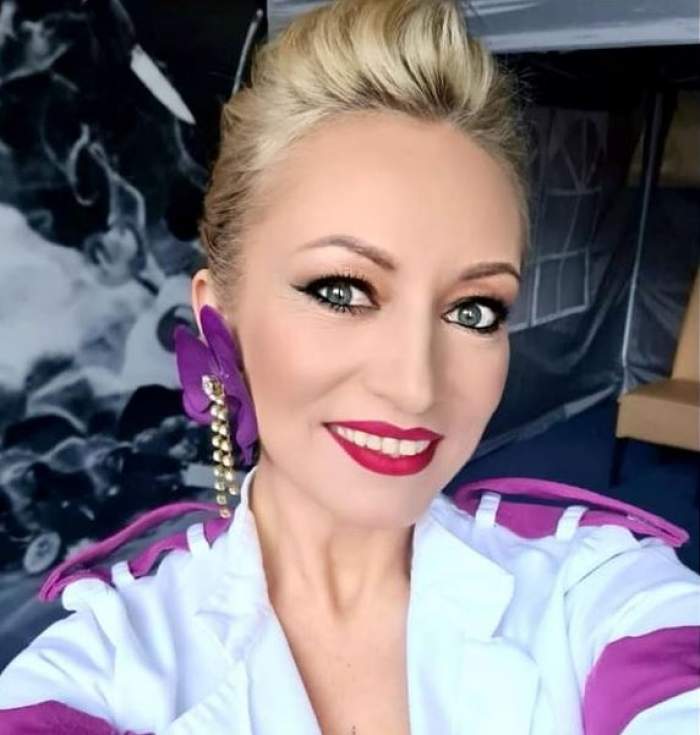 Nicoleta Pop își face un selfie în care zâmbește și poartă uniformă albă de bucătar cu nuanțe de mov.