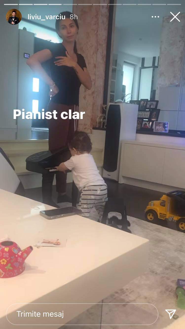 Anda Călin și fiul ei sunt în sufragerie. Micuțul cântă la pian, iar mama lui e îmbrăcată cu tricou negru.