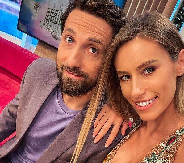 Gabriela Prisăcariu și Dani Oțil într-un selfie. Ea poartă o rochie crem, brodată, iar el sacou și tricou lila.