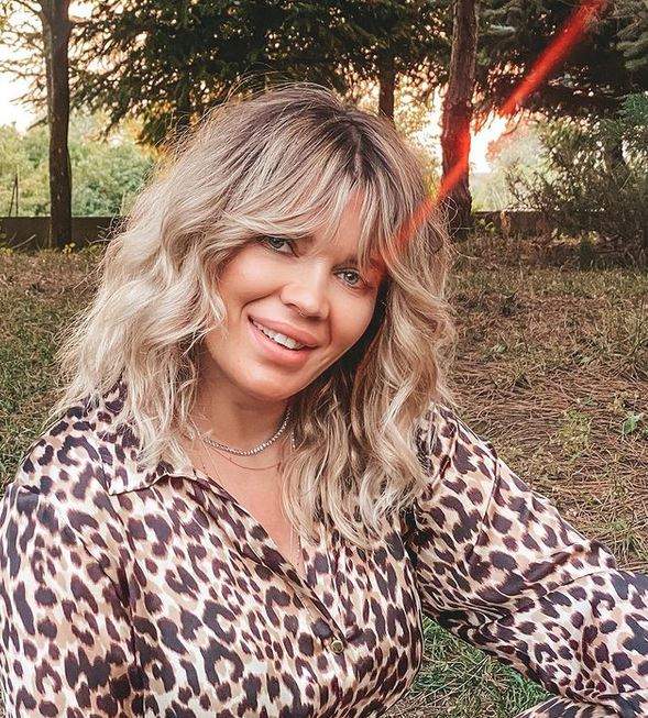 Gina Pistol e îmbrăcată într-o cămașă cu animal print, stil leopard. Vedeta zâmbește larg.