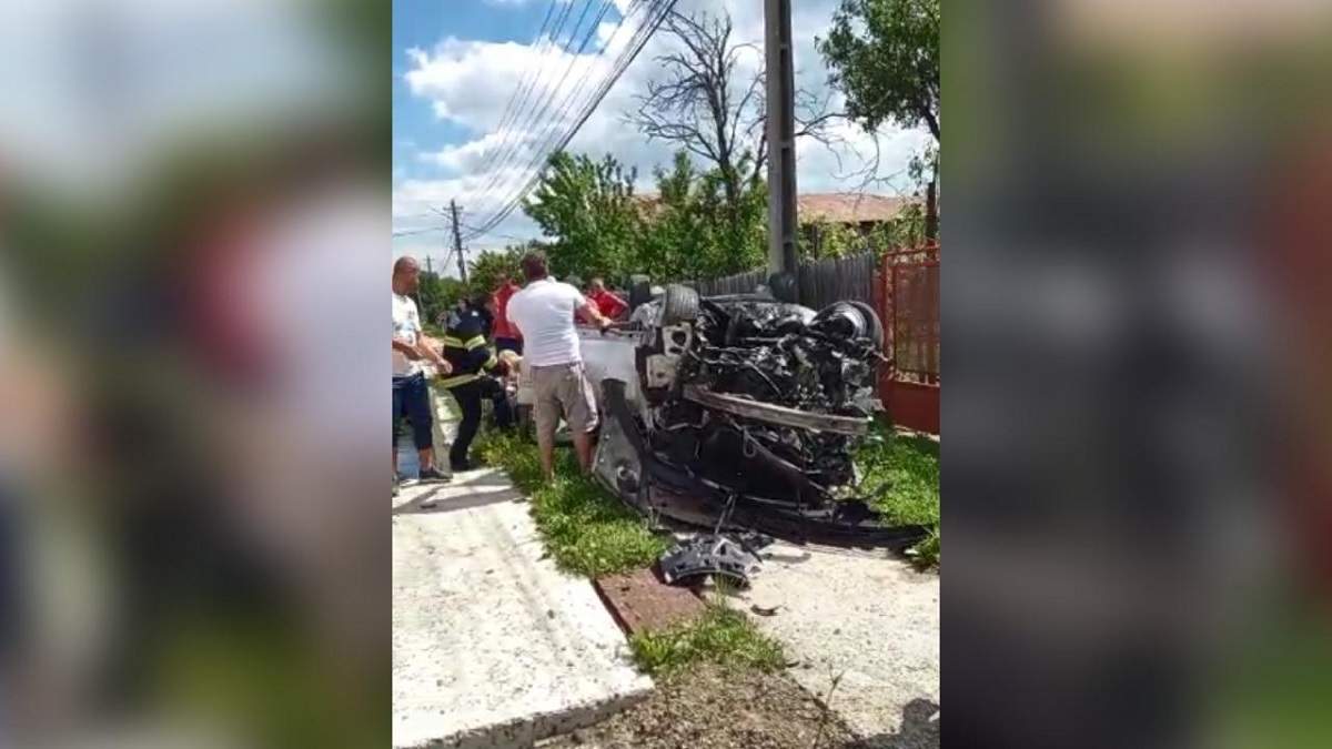 Imagine cu accidentul din județul Prahova, în care un bărbat a murit și o femeie a fost rănită. Mașina lor e răsturnată, iar lângă ea sunt mai mulți oameni.