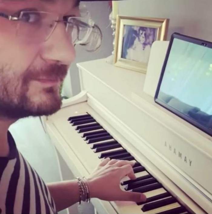Florin Dumitrescu cântă la pian și poartă ochelari de vedere și tricou în dungi albe și negre.