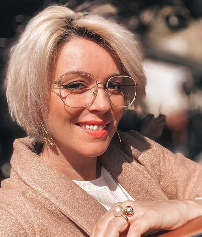 Diana Dumitrescu poartă ochelari de vedere și zâmbește.