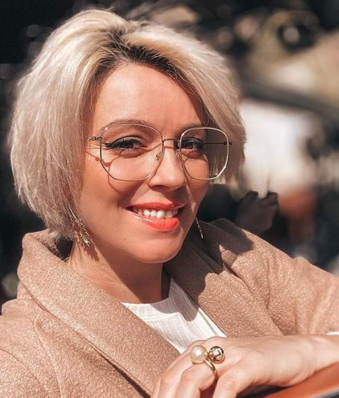 Diana Dumitrescu poartă ochelari de vedere și zâmbește.