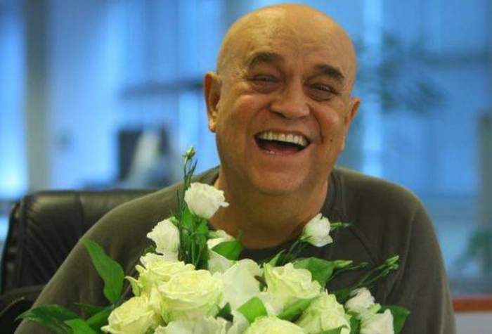 Benone Sinulescu, râzând, cu un buchet de flori în față