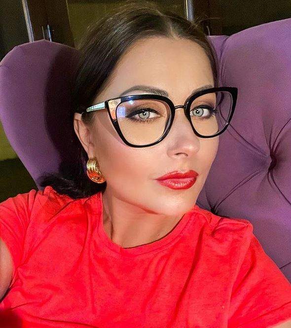 Gabriela Cristea își face un selfie. Vedeta stă pe un fotoliu mov, poartă ochelari de vedere și un tricou roșu.