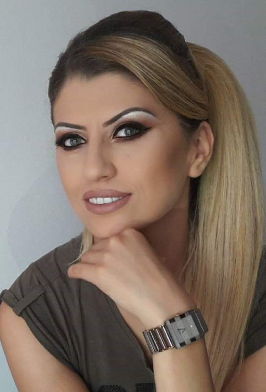 Alina Radi, cu mâna la barbă, zâmbitoare, în ținută închisă la culoare