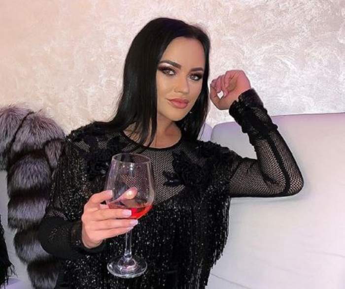 Carmen de la Sălciua, în ținută neagră, cu un pahar de vin în mână