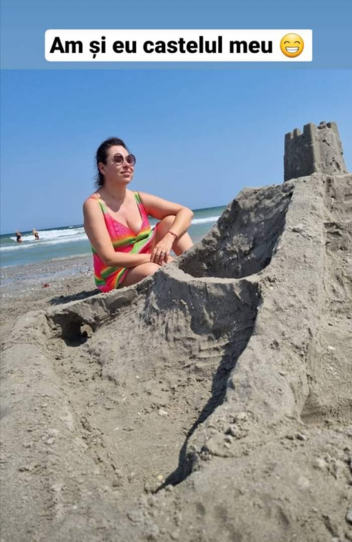 Oana Roman, în costum de baie, lângă un castel de nisip