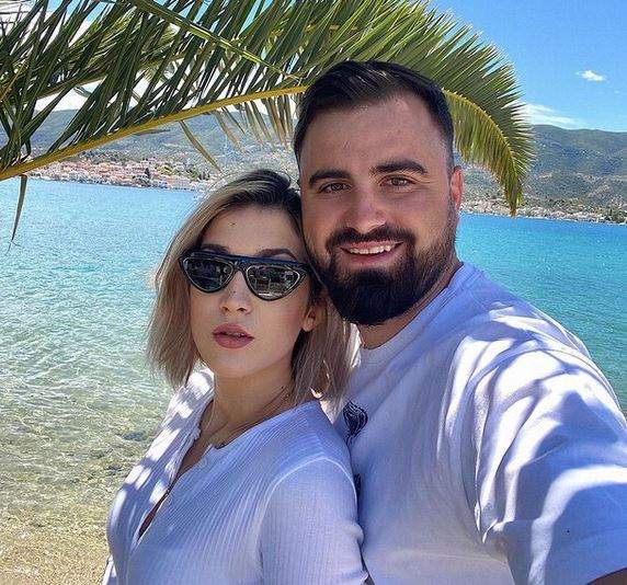 Adda și Cătălin Rizea sunt în vacanță în Grecia și stau lângă mare. Amândoi poartă tricouri albe.
