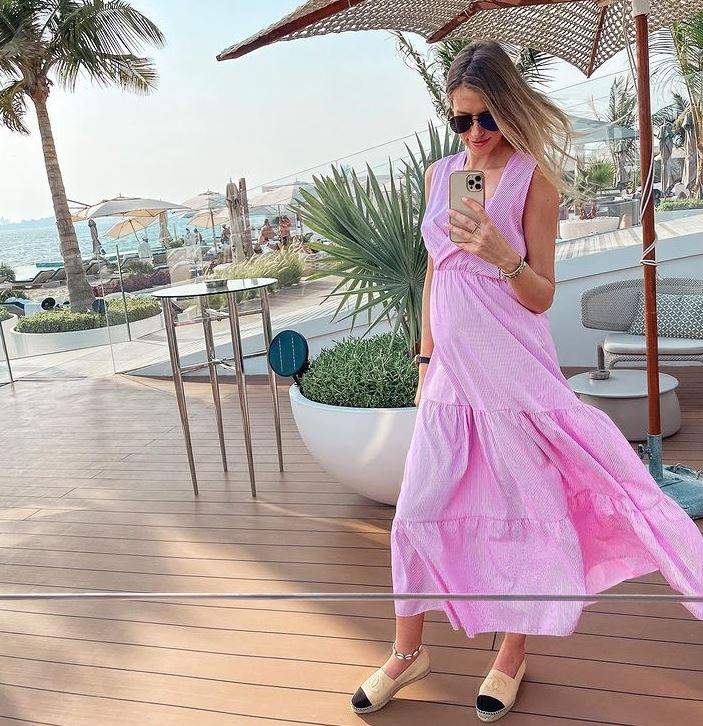 Gabriela Prisăcariu e pe terasă la mare, paortă rochie roz și își face poză cu telefonul în oglindă.