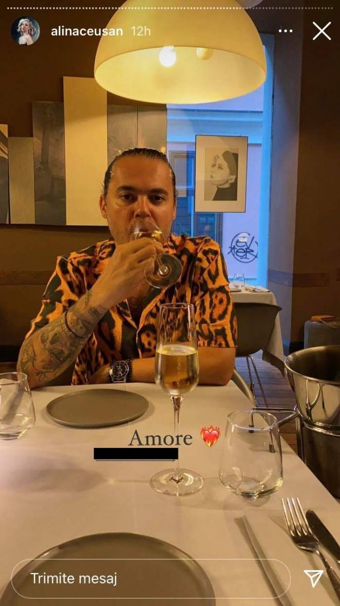 Raul Tisa e la restaurant și bea din pahar. Soțul Alinei Ceușan poartă o cămașă cu animal print, iar deasupra lui e o lampă aprinsă.