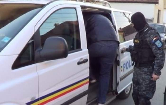 Oamenii legii lângă duba de poliție