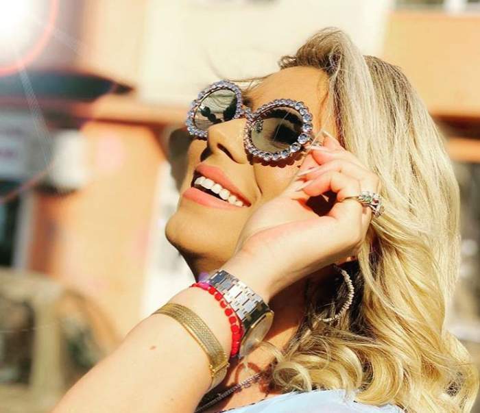 Roxana Diță, zâmbitoare, cu ochelari de soare pe față