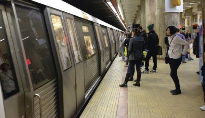 Oameni așteptând pe peron metroul