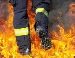 Un pompier care merge prin flăcări