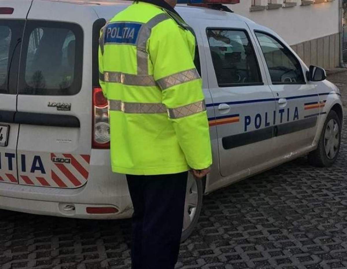 Om al legii lângă mașina de poliție