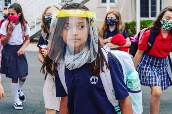 O elevă cu mască de protecție pe față