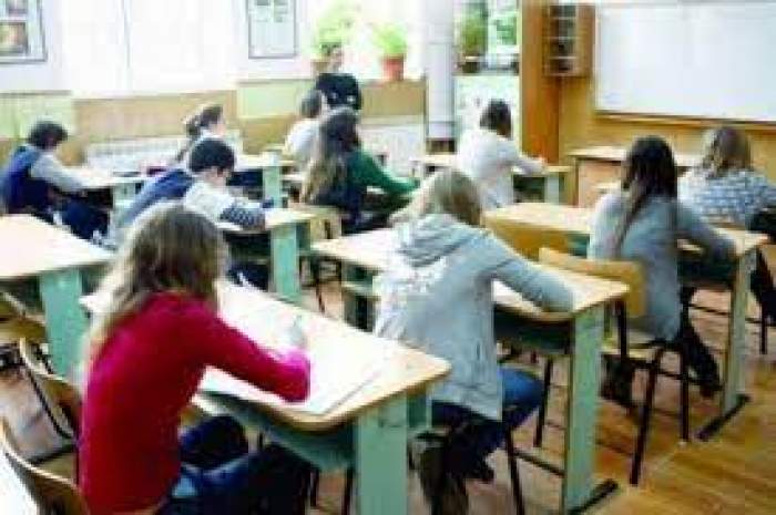 O sala de curs plină de elevi care scriu