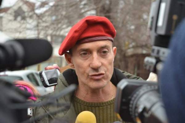 Radu Măzare, dă interviuri, cu șapcă roșie pe cap