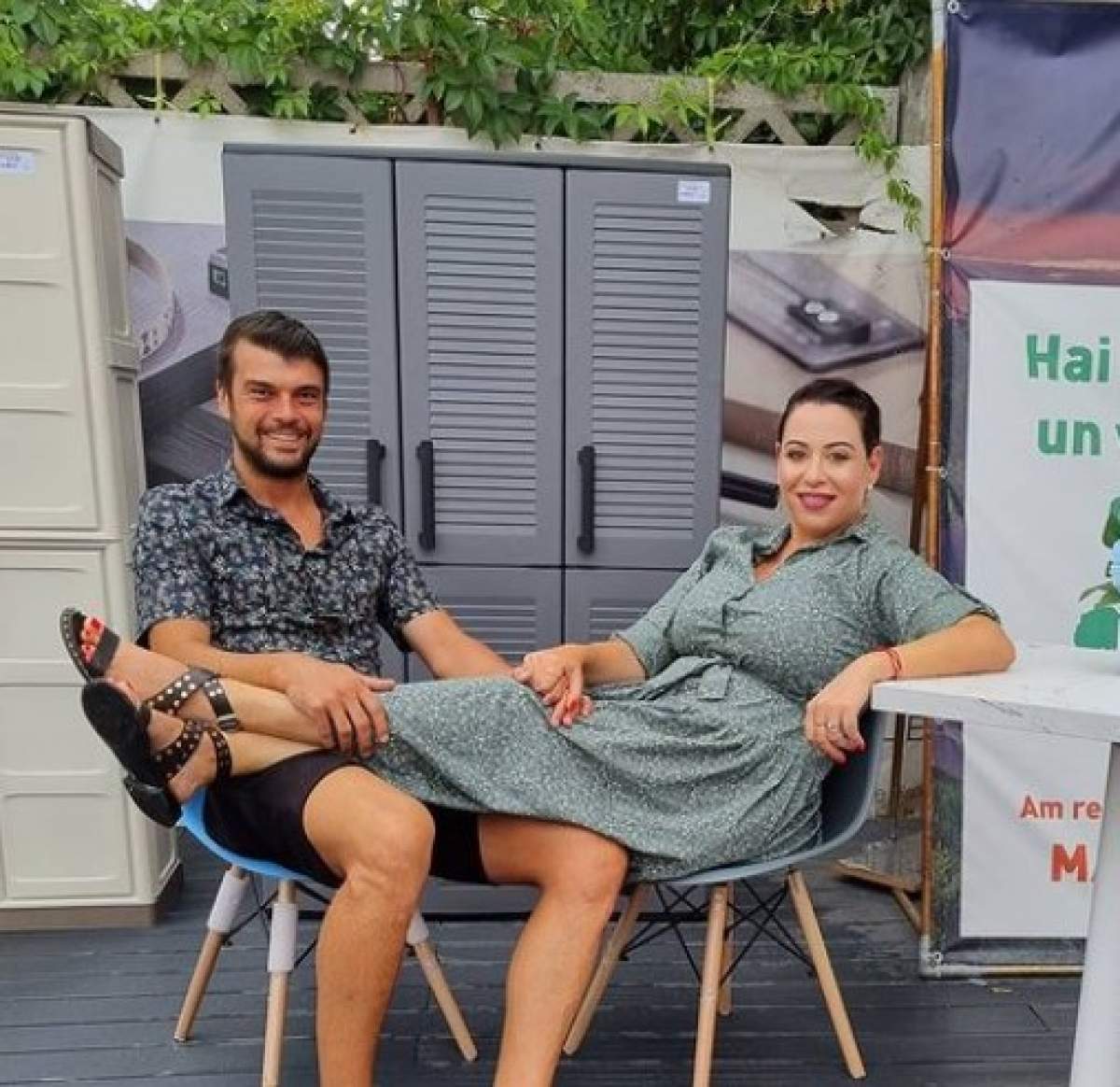 Marius Elisei și Oana Roman așezați pe scaune, ea își ține picioarele în poala lui