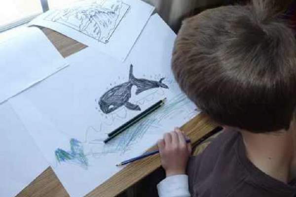 Un copil care desenează balena albastră