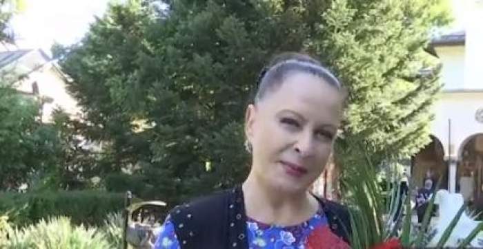 Maria Dragomiroiu , cu flori în brațe, zâmbitoare