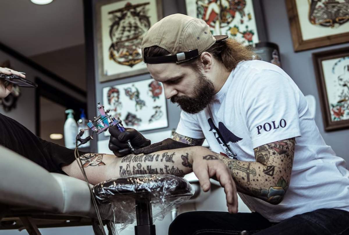 tatuator în timp ce face un tatuaj