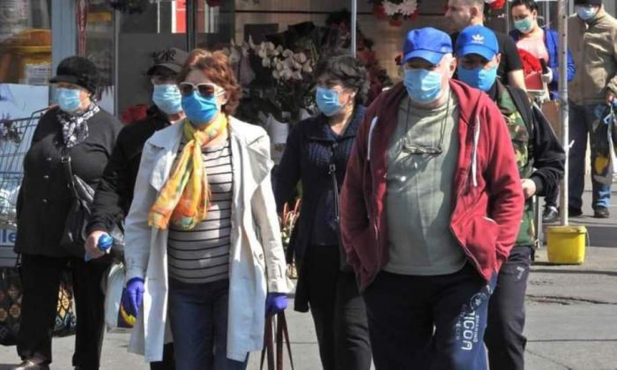 oameni cu mască pe stradă