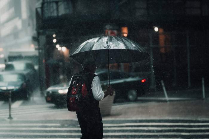 bărbat cu umbrelă prin ploaie