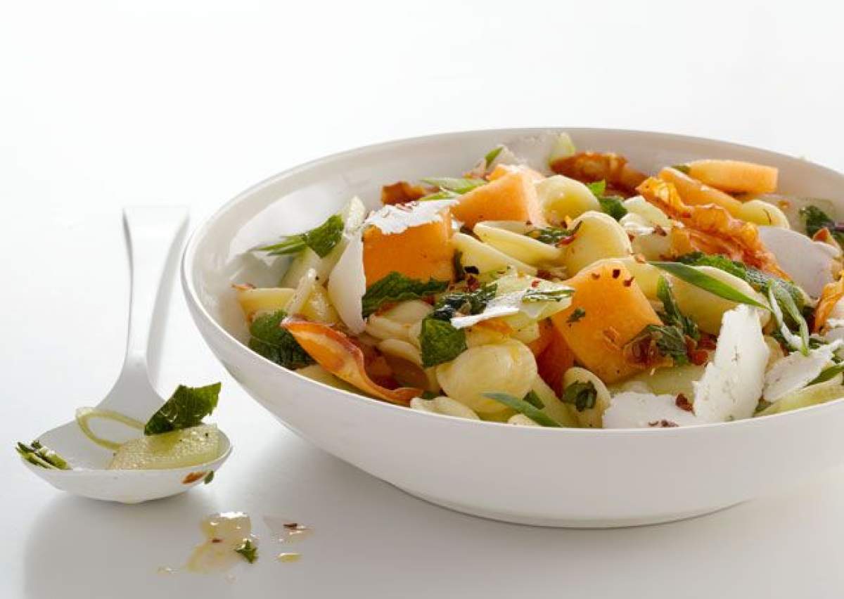 Se fac în mai puțin de 30 de minute Paste cu pepene galben, mozzarella și prosciutto. Rețeta unui preparat cu specific italienesc, ideal pentru zilele de vară