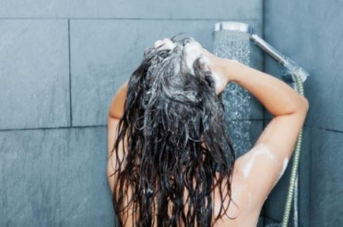 femeie în duș care se spală pe cap
