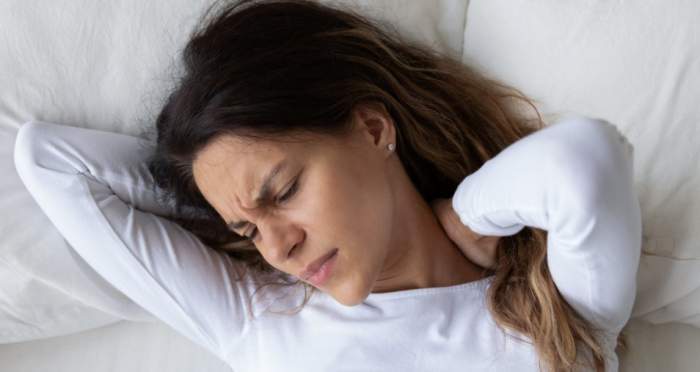 O femeie care doarme și pare că nu se simte bine