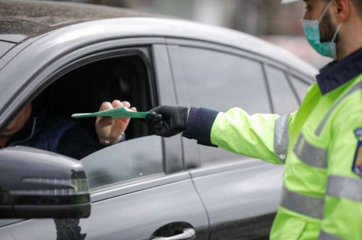 Polițist în timp ce îi da actele unui șofer.