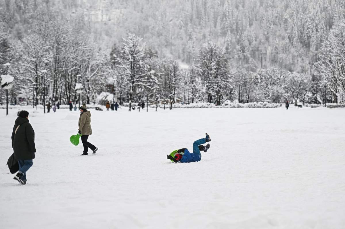 Copii care se joacă în zăpadă.