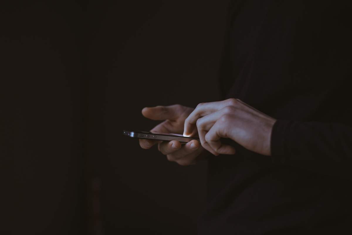 O persoană cu un telefon în mână.