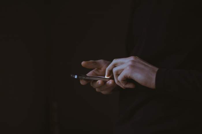 O persoană cu un telefon în mână.