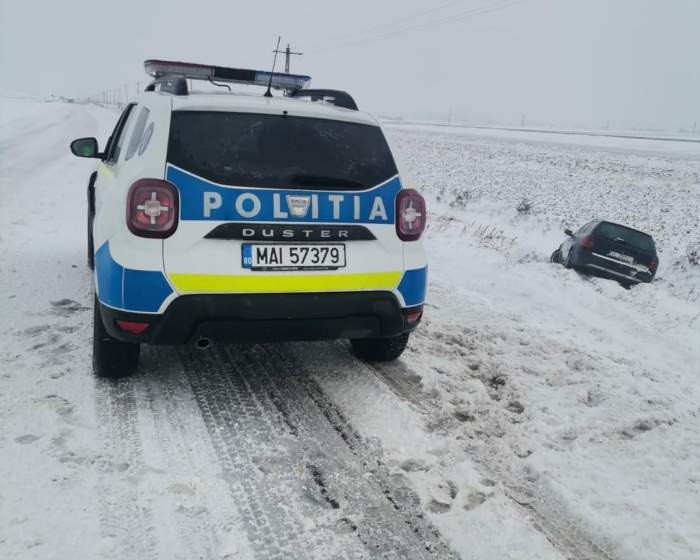 O mașină de poliție pe un drum cu zăpadă.