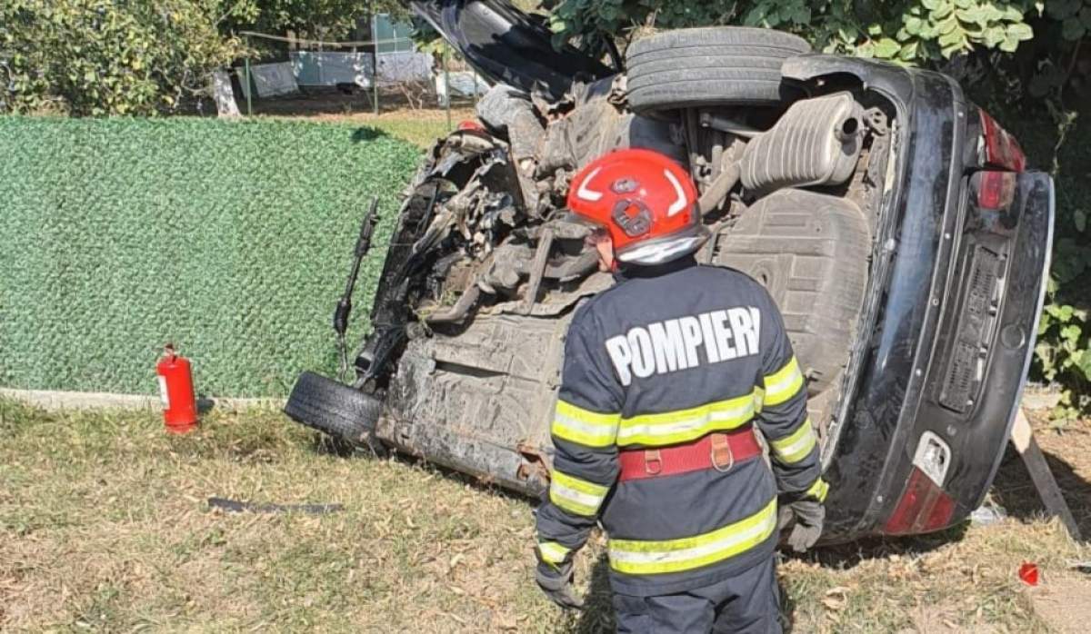 Pompierii l-au scos pe tânăr de sub fiare. Mașina răsturnată în șanț