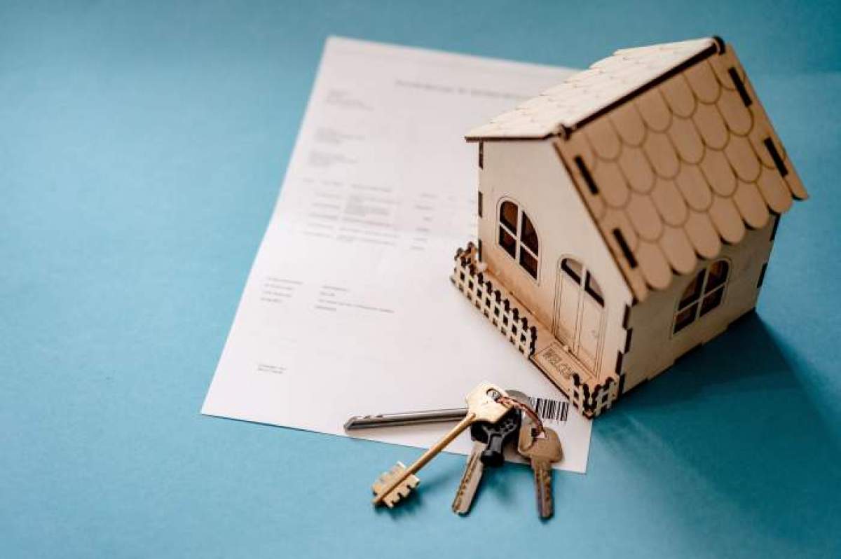 o casă din lemn, un document și niște chei