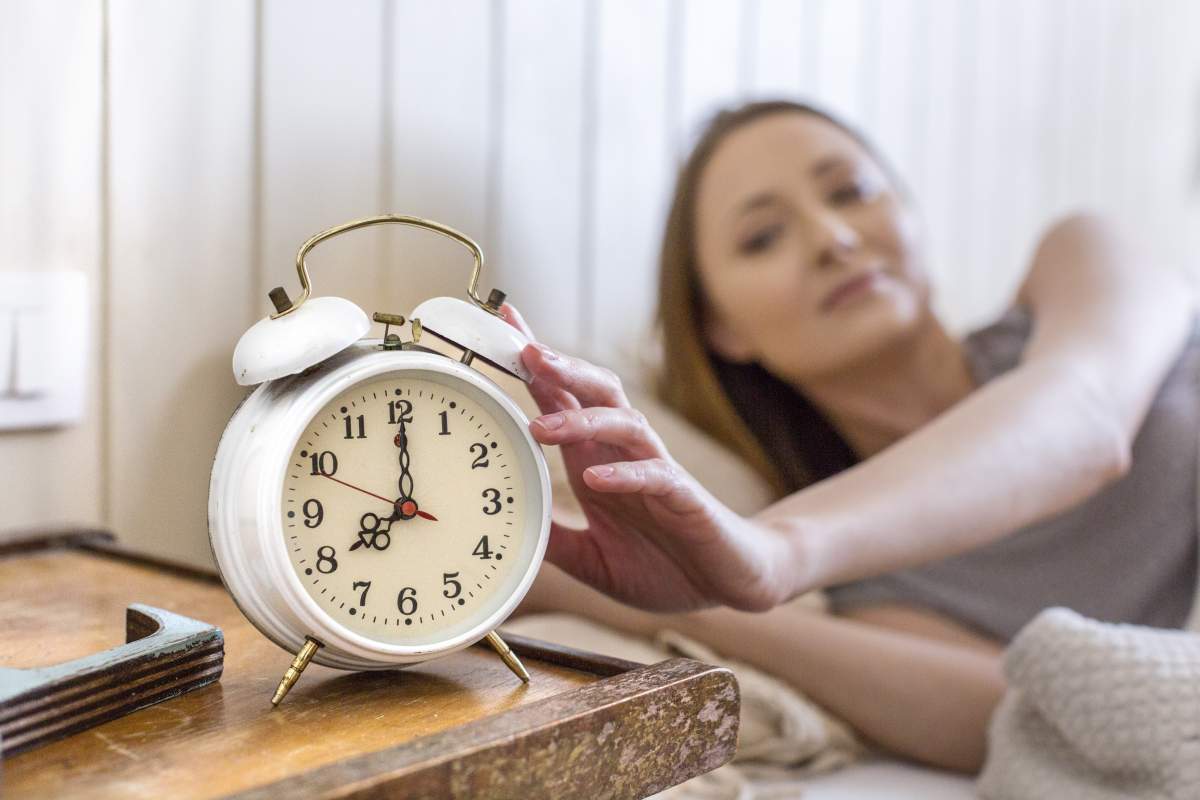 O femeie care oprește alarma la ceas