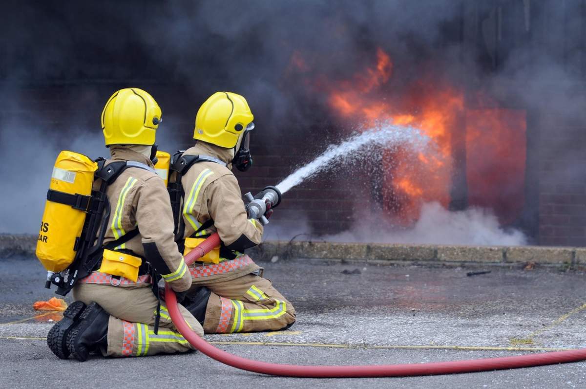 doi pompieri care sting un incendiu